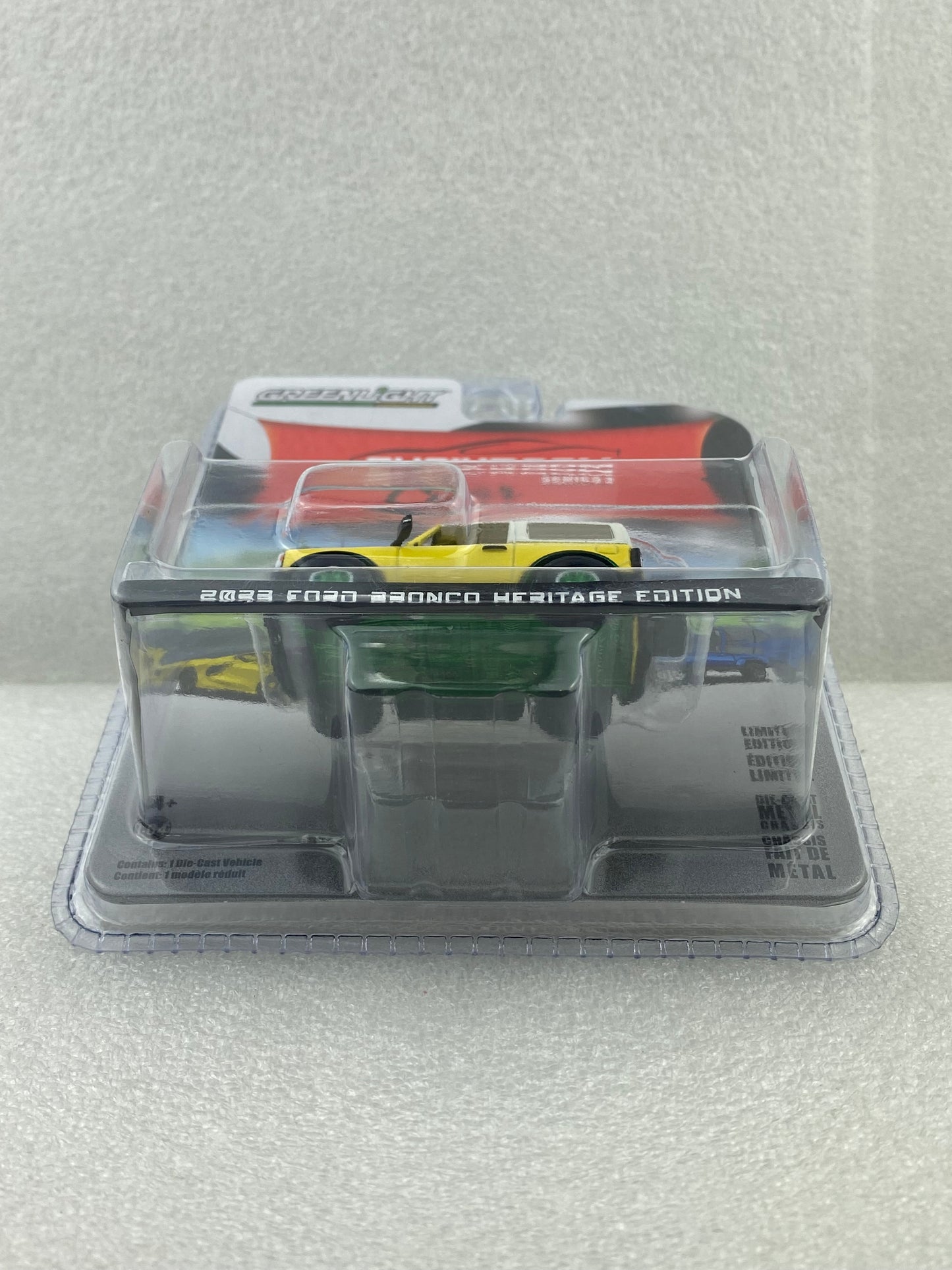 GreenLight Green Machine 1:64 Showroom Floor Series 3 - 2023 Ford Bronco 2-Door Heritage Edition - Yellowstone Metallic with Oxford White Roof 68030-D
