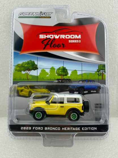 GreenLight Green Machine 1:64 Showroom Floor Series 3 - 2023 Ford Bronco 2-Door Heritage Edition - Yellowstone Metallic with Oxford White Roof 68030-D