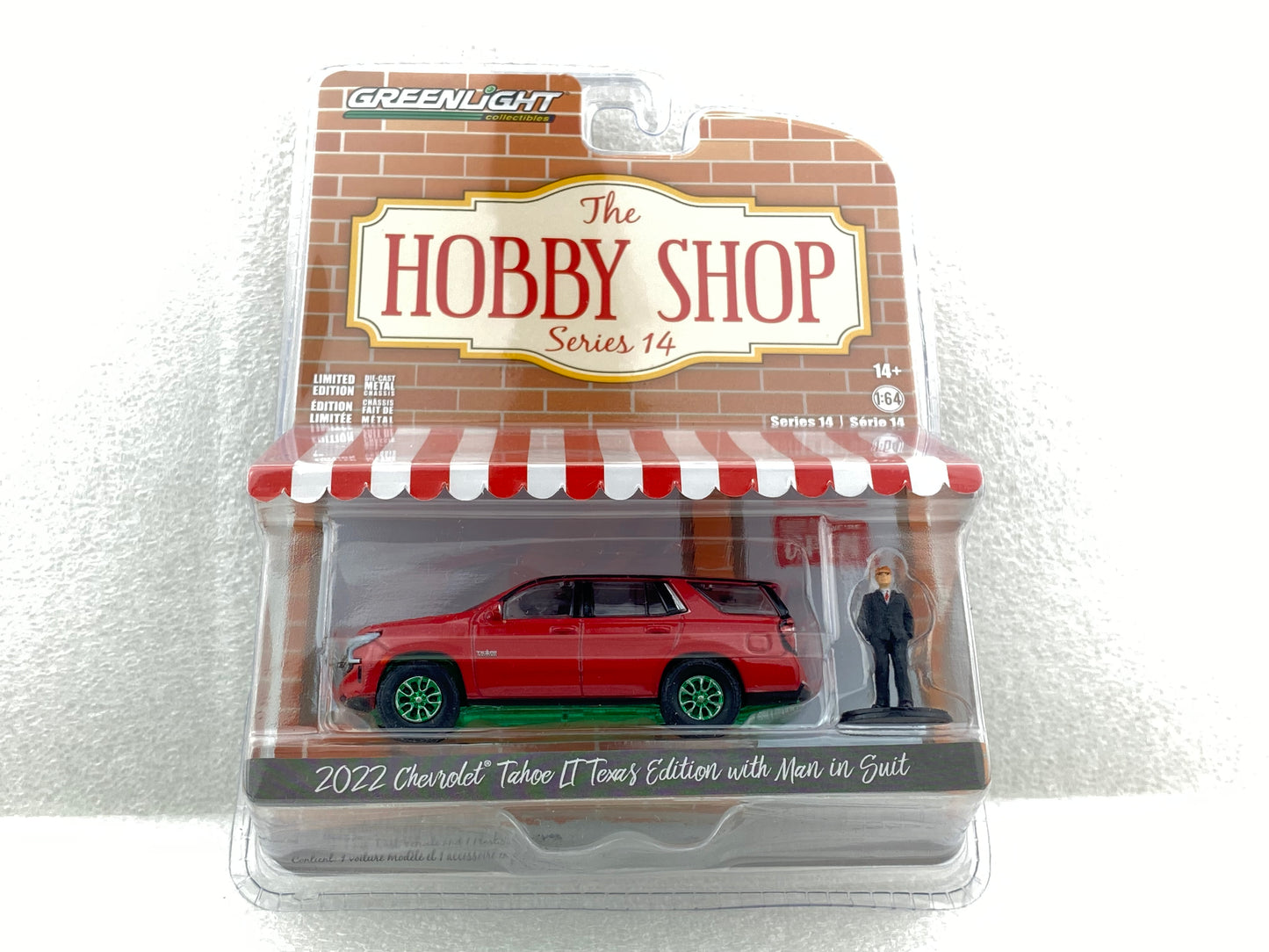 GreenLight Green Machine 1:64 The Hobby Shop Series 14 - 2022 Chevrolet Tahoe LT Texas Edition with Man in Suit 97140-F